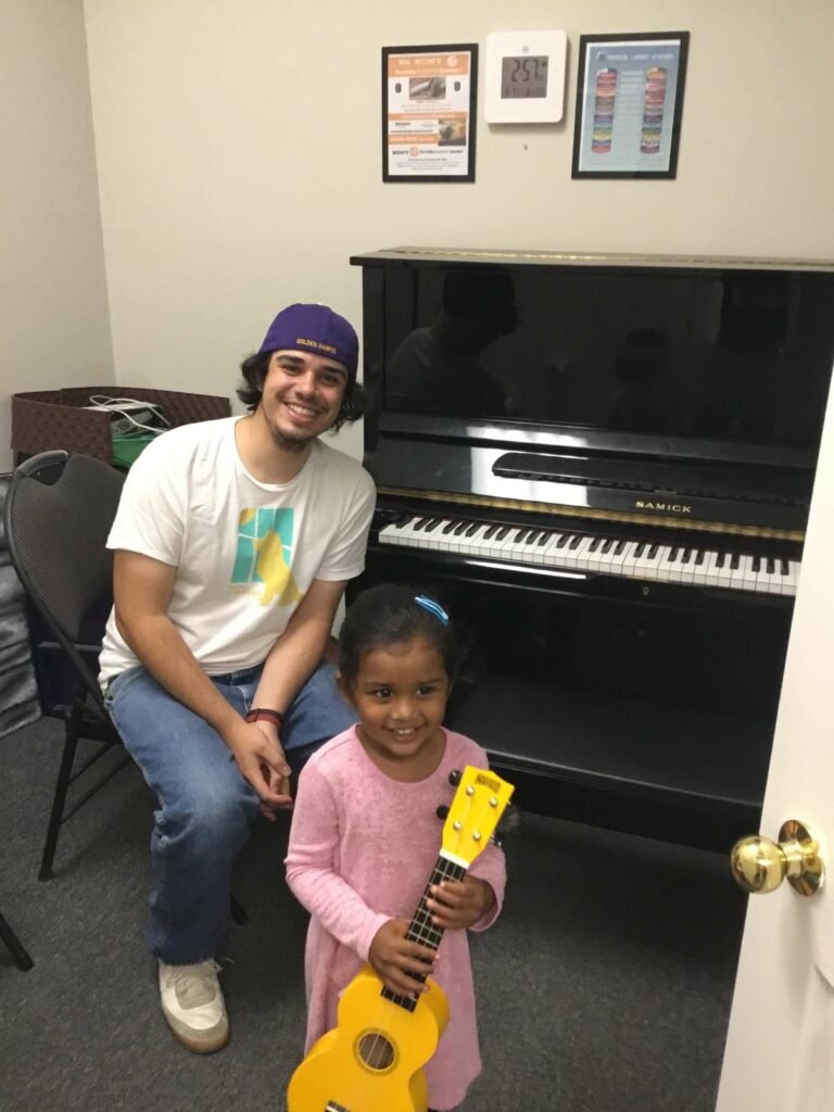 young ukulele playing music student and her teacher
